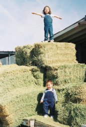 Amina and Adam playing on the hay